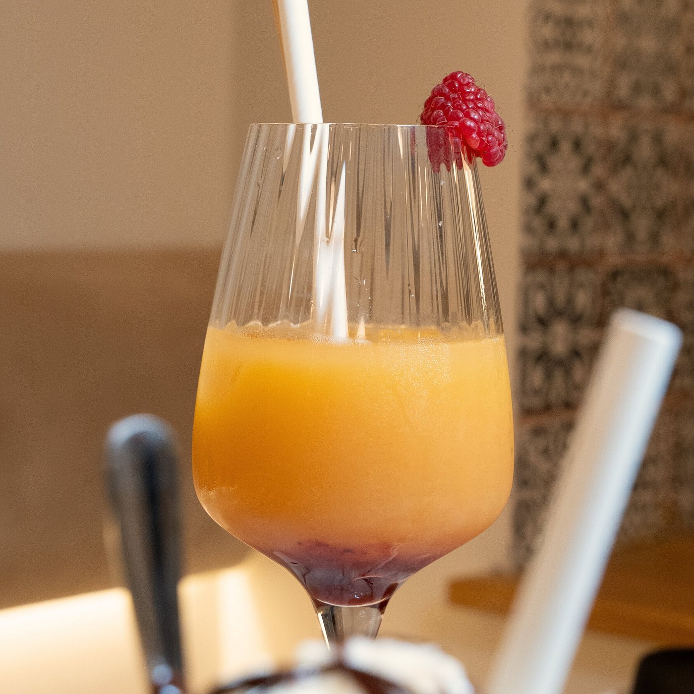 Madame Monsieur layered orange cocktail mocktail with a fresh raspberry in Budapest